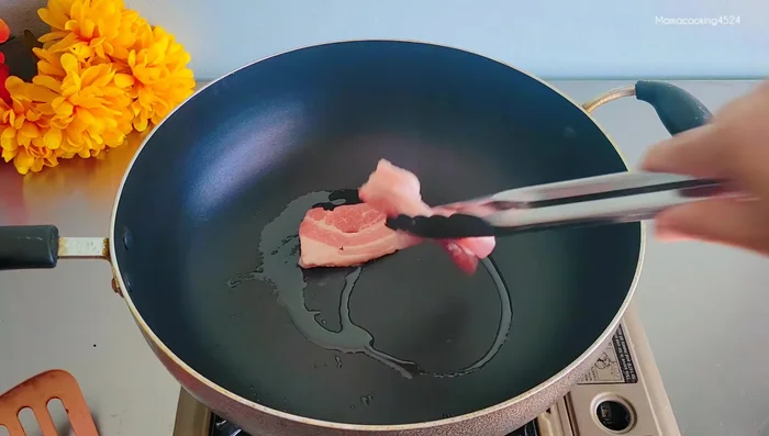 Stir-fry pork belly: Add pork belly to the pan and stir-fry until fragrant and browned. Add rock sugar (optional).