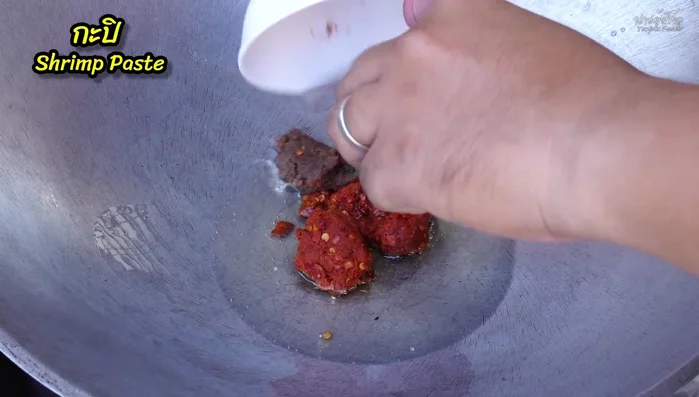 Add chili, red curry paste, and shrimp paste. Stir-fry until fragrant.