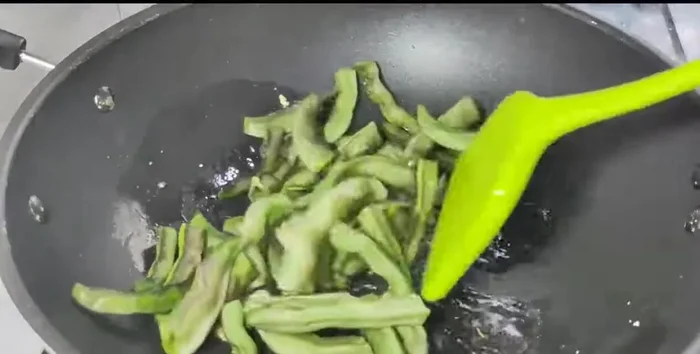 Add the green beans and stir-fry until they are almost cooked.