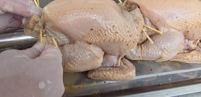 Skewer the chicken, securing the wings and separating the head (optional).
