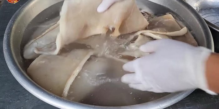 Rinse the boiled pork skin with cool water to remove grease.