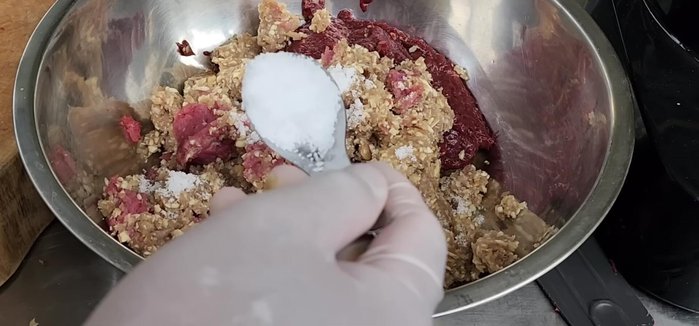 Season the meat mixture: Add salt, roasted rice, Isan flavoring powder, sugar (optional), and sticky rice. Mix thoroughly.