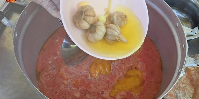 Add palm sugar/coconut sugar (1200 grams), pickled garlic water (1200 grams including the bulb), granulated sugar (400 grams), salt (7 heaped spoons), and MSG (optional). [129.2]