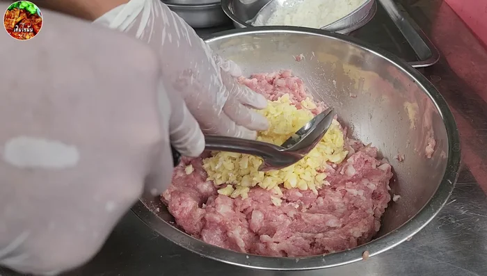 Add Garlic and Rice: Add 200 grams of garlic and 200 grams of washed sticky rice. Mix thoroughly for about 20 minutes until all ingredients are well combined.