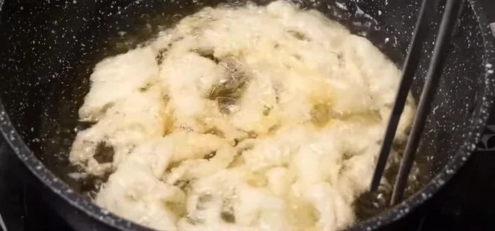 Flip the noodles to ensure even cooking and crispness.