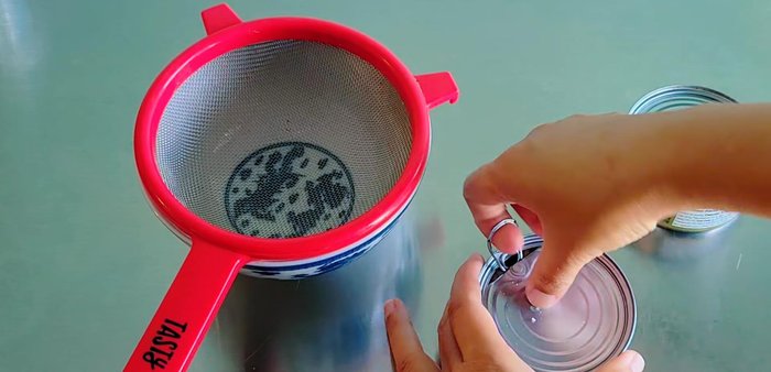 Prepare the filling: Drain two cans of tuna. (141.4)