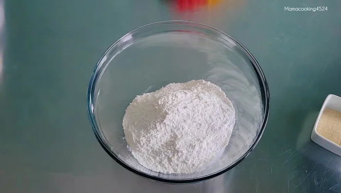 Gradually add heated coconut milk to the flour mixture, mixing until a soft, non-lumpy dough forms. Knead for about 5 minutes.