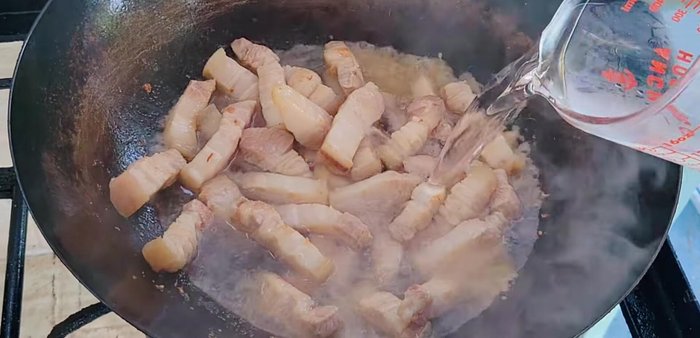 Add red curry paste. Add water until it covers the pork.