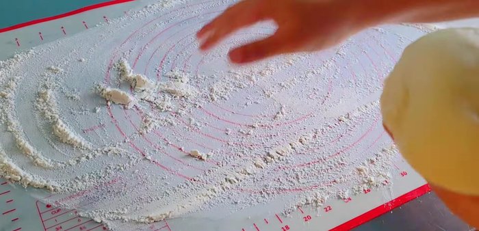 Roll out the pizza dough to about 12 inches in diameter and 5mm thickness. Place on a baking tray and press the edges to create a small rim. Poke holes in the dough with a fork.