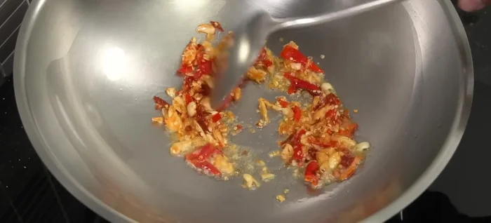 Once the oil is hot, add the chili and garlic. Stir-fry until fragrant.