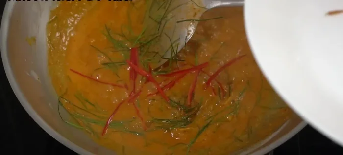 Stir in shredded kaffir lime leaves and red chilies.