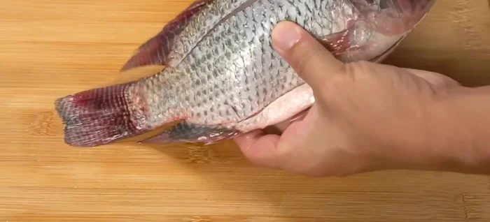 Score the tilapia and sprinkle with salt.