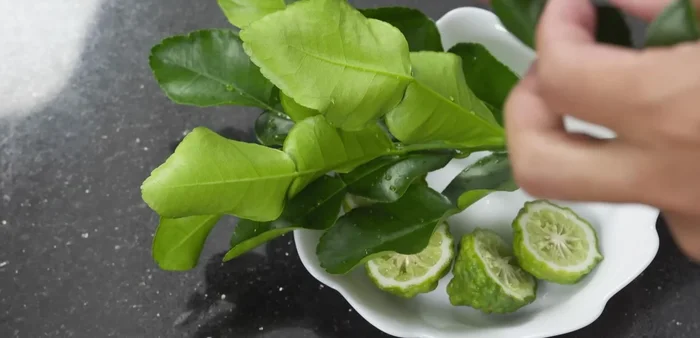 Prepare the kaffir lime leaves by removing the stems and folding them in half.