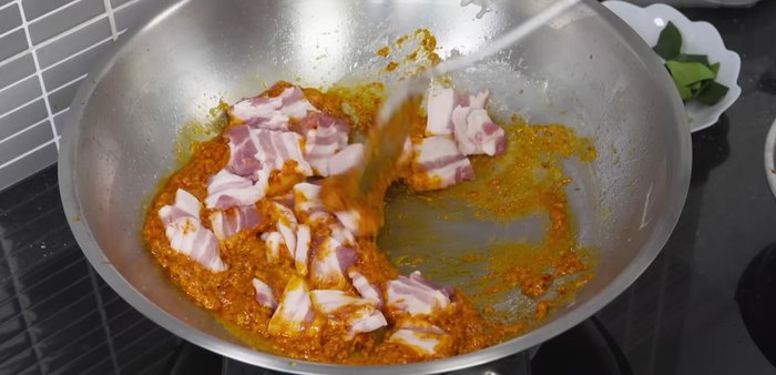 Add the pork belly and stir-fry until well blended with the curry paste.