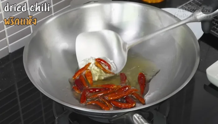 Prepare the dipping sauce ingredients: Fry dried chilies until golden brown and fragrant.