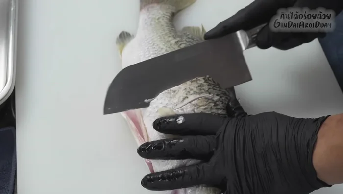 Score the sea bass: Make slanted cuts to help it puff up during frying.