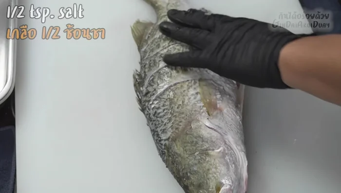 Season the sea bass: Sprinkle with salt.