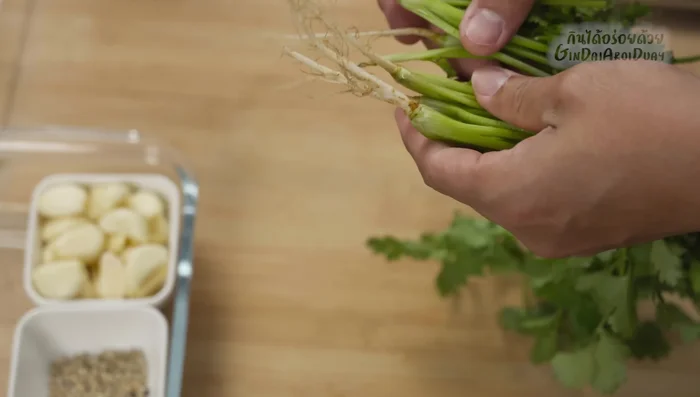 Prepare the aromatics: Pound garlic, peppercorns, and coriander root until finely ground. (48.879)