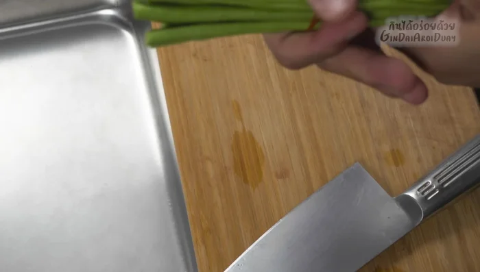Prepare the long beans: Wash and tie them with a rubber band before chopping into thin slices.