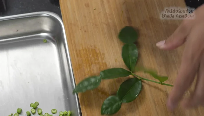 Prepare the kaffir lime leaves: Wash and remove the central stem. Tear the leaves into smaller pieces.
