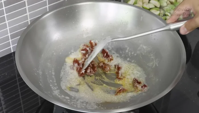 Add red curry paste to the coconut oil and stir-fry until fragrant (243.84).
