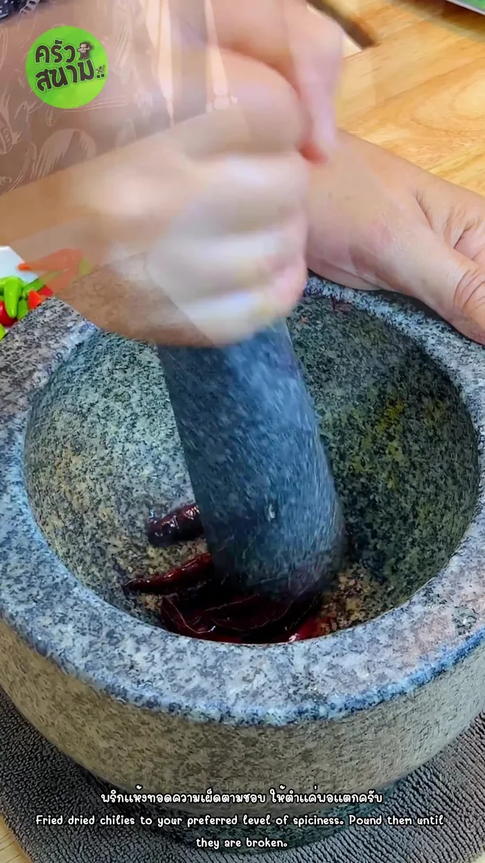 Pound the dried chili until it breaks up.