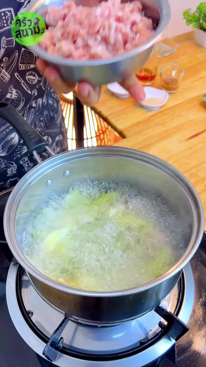 Add 300 grams of minced pork to the boiling broth, press it down and break it apart to spread it out.