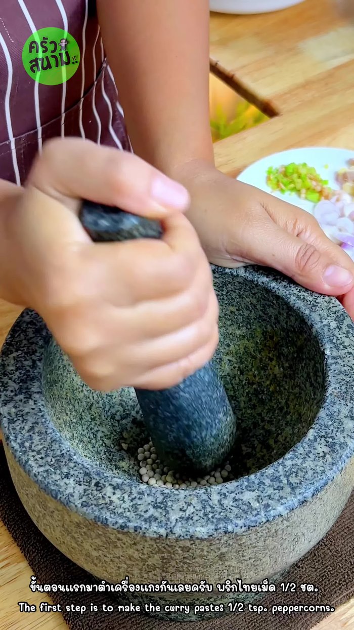 Pound the ingredients: peppercorns, coriander roots, ginger.