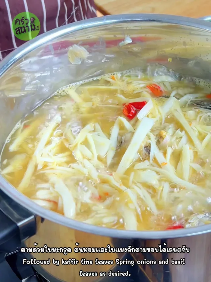Add kaffir lime leaves, torn shallots, and galangal leaves. Press down the vegetables to submerge them in the water. Continue to boil until the vegetables are wilted.