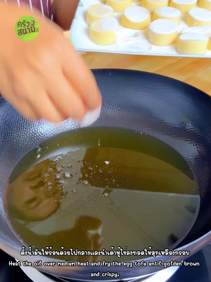 Heat oil in a pan over medium heat. Add the egg tofu and fry until golden brown and crispy, ensuring one side sets before flipping.