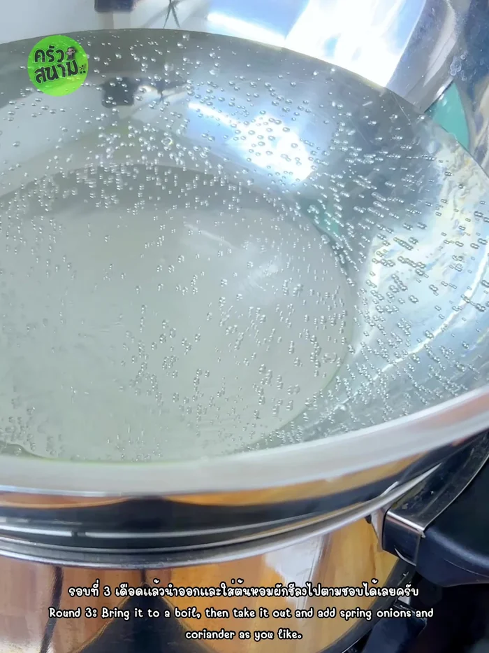 Once the water is boiling, add chopped spring onions and coriander. Mix well and continue boiling until vegetables are cooked.