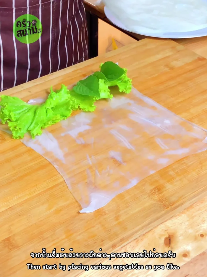Add desired vegetables (lettuce, basil, mint, parsley, shredded carrots) to the center of the noodle sheet.
