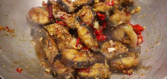 Stir-fry garlic and chilies in a wok.
