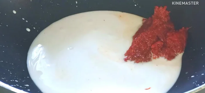 Put coconut milk in a pan and add red curry paste. Cook over medium heat until the coconut milk boils and separates.