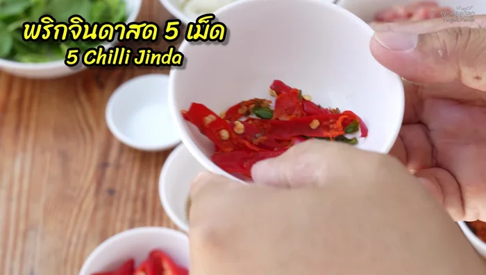 Pound the fresh chili peppers.