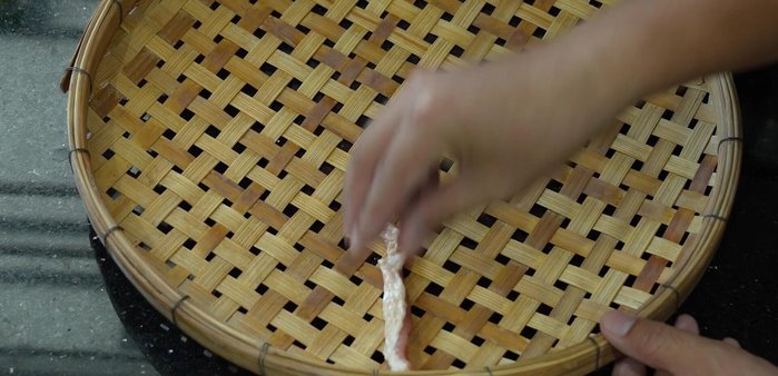 Arrange the marinated beef in a single layer on a wooden winnowing basket or similar surface.