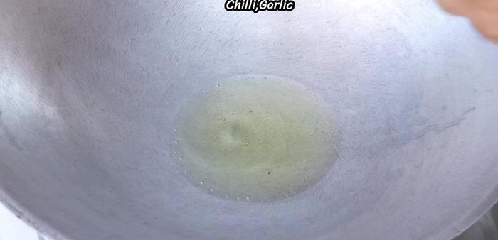 Add the chili and garlic to the pan and stir-fry until yellow and fragrant.
