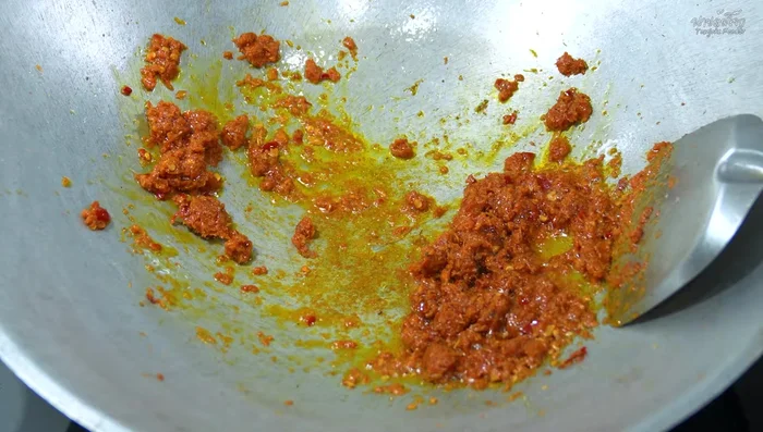 Add lime leaves and kaffir lime leaves to the curry paste and stir-fry until fragrant.