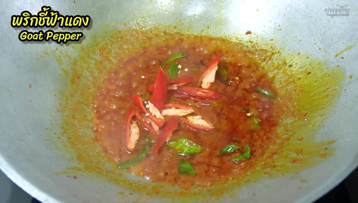 Add chopped red chili peppers and the boiled long beans. Stir-fry until the chilies are cooked.