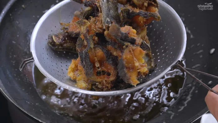 Once fried, remove the fish and drain the oil using a sieve. Let it cool and separate into pieces for easier eating.