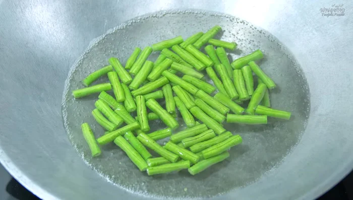Boil the yardlong beans until cooked but still slightly crisp. Shock in cold water.