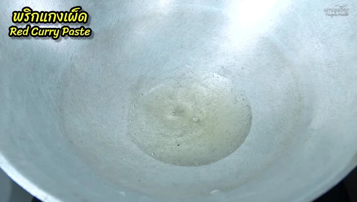 Heat oil in a pan. Add red curry paste and stir-fry over low heat until fragrant and slightly yellow.