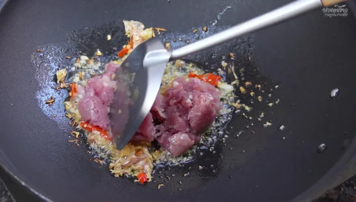 Add the minced pork and stir-fry until about 80-90% cooked.