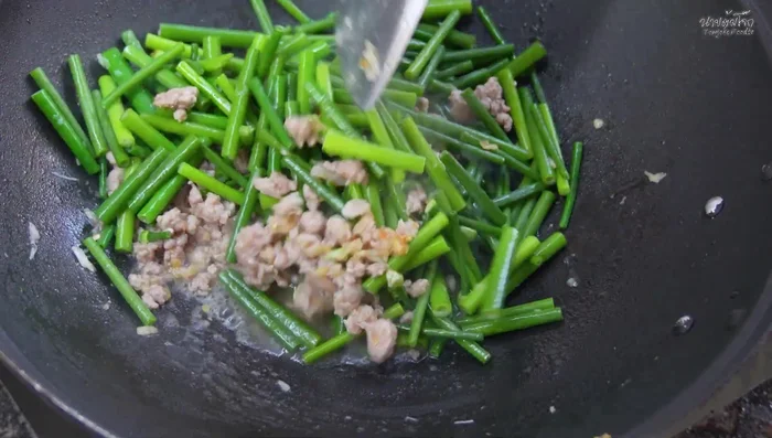 Once the water boils, add oyster sauce, green-capped seasoning sauce, fish sauce, and sugar. Stir-fry until well combined.