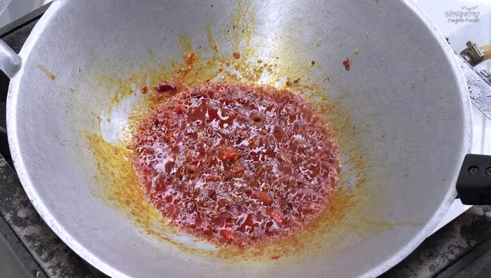 Stir-fry until the palm sugar dissolves, then add chili peppers.