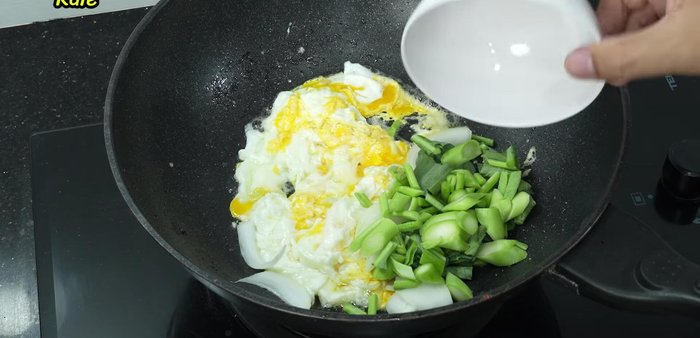 Add onions and chopped kale, stir-frying until the kale is cooked.