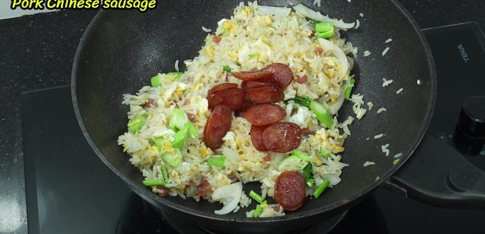Add the fried Chinese sausage back into the pan and stir-fry together.