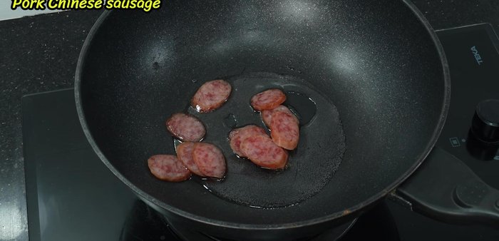 Fry the Chinese sausage in pieces until lightly cooked, using low heat to prevent burning.