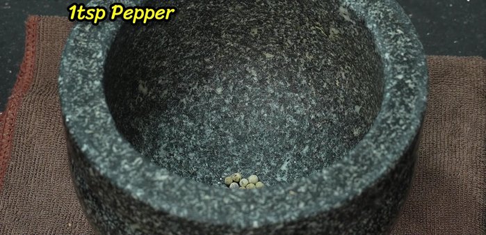 Pound garlic, chili peppers, and peppercorns (or Thai chili powder) in a mortar and pestle. Add a little water to create a paste.