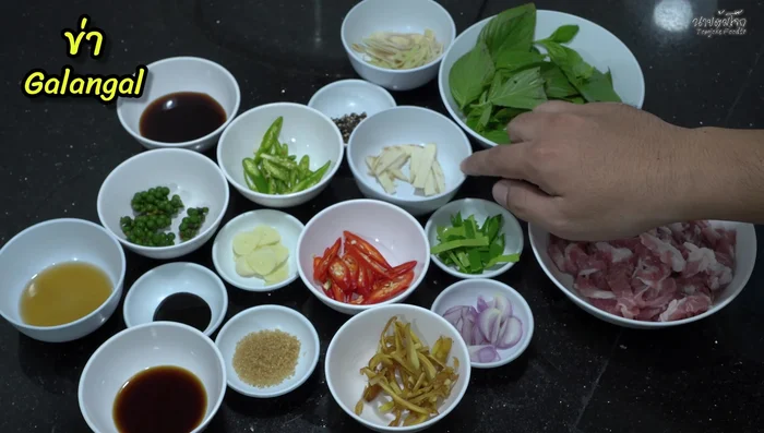 Prepare the herbs: Chop lemongrass and chili into thin strips. Crush Thai chili. Chop kaffir lime leaves, shallots, galangal, Jinda chili, and green chilies.